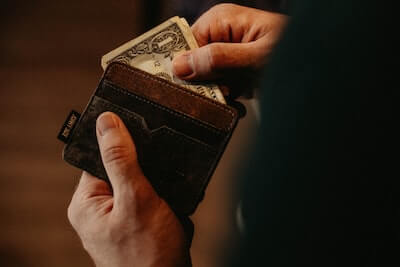 hands pulling money out of a wallet